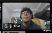 a man wearing glasses and headphones is on a video call with the name droid .