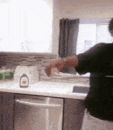 a bottle of maple syrup sits on a kitchen counter