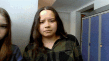 a girl in a plaid shirt is standing next to another girl