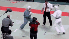 a man taking a picture of a karate match with the website 4cles.com