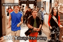 a group of people are walking down a hallway in a school .