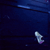 a shoe is hanging from the ceiling next to a phone that says ' nike ' on it