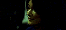 a close up of a woman 's face with a dark background