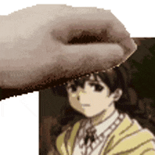 a pixelated image of a hand touching a girl 's head .