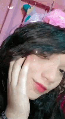 a close up of a girl 's face with her hand on her face