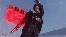 a man is holding a sword with a red light coming out of it