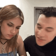 a man and a woman are sitting next to each other in a room .