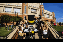 a group of cheerleaders are standing on a set of stairs in front of a large building that says tower
