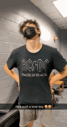 a man wearing a black shirt that says ac dc on it