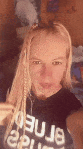 a woman with blonde hair is wearing a black shirt that says bruno
