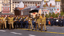 a group of soldiers march in front of a building that says 100