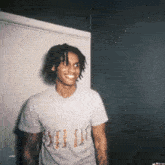a young man wearing a t-shirt that says supreme is smiling