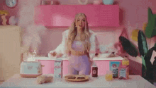 a woman in a purple outfit is standing in front of a table with food on it .