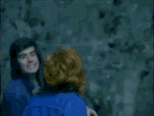 a blurry picture of a woman in a blue jacket crawling on the ground