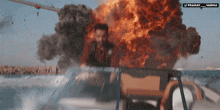 a man in a boat is in front of a large explosion and the words pranay varha are above him