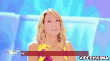 a woman is smiling in front of a screen that says domenica