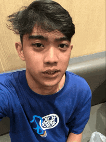a young man wearing a blue shirt with the number 3 on it takes a selfie