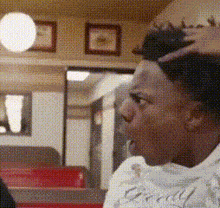 a man with a tattoo on his head is sitting in a diner .