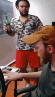 a man holding a bottle of beer is standing next to another man