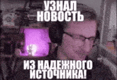 a man wearing headphones and glasses is sitting in front of a computer screen with a purple light behind him .