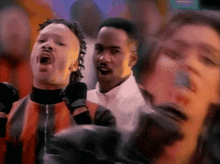 a group of people are standing in a crowd and one of them is wearing a mask that says ' a ' on it