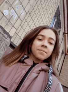a girl wearing a pink jacket with the word fashion on the sleeve