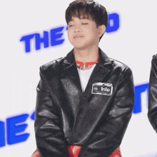 a young boy wearing a black leather jacket has a name tag that says into