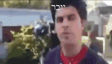 a blurry picture of a man in a red shirt with hebrew writing on it