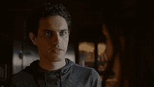 a man and a woman are looking at each other in a dark room .