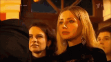 a group of people are watching a show with the number 7 on the bottom right corner
