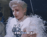 a man in a white feathered outfit with chinese writing on the bottom right