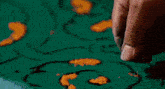 a man in a red shirt is kneeling on a colorful carpet