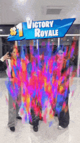 three people are standing in front of a victory royale sign