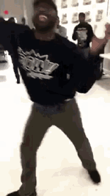 a man wearing a shirt that says ' army ' on it is dancing