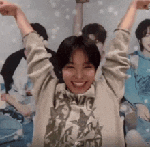 a person wearing a sweatshirt with the word sonic on it is smiling with their arms in the air