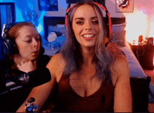 a woman wearing headphones and a shure microphone smiles for the camera