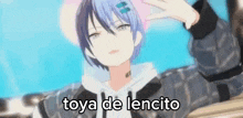 a boy with blue hair is taking a picture of himself with his hand and the words `` toya de lencito '' .