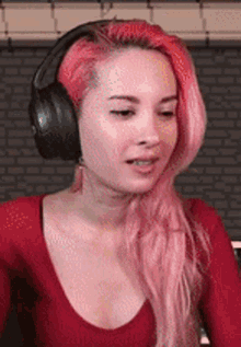 the woman is wearing headphones and a red shirt .