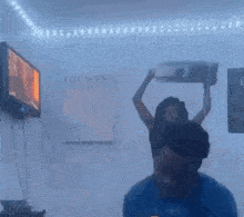 a person is wearing a fan on their head in a room .