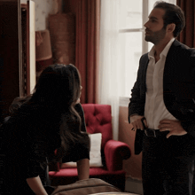 a man in a suit and white shirt stands next to a woman