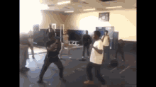 a group of young men are standing in a gym fighting each other