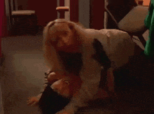 a woman is laying on the floor with her head on another woman 's stomach