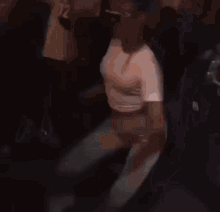 a woman in white pants and sunglasses is dancing in a crowd