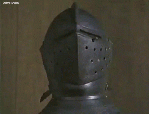 A GIF of a dog popping out of an ancient-looking knight's helmet. Cute!