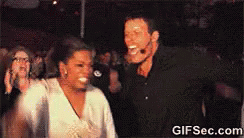 Oprah in a frenzy, running across hot coals, cheered on by Tony Robbins