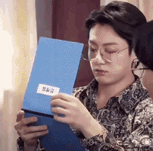 BTS Jungkook looking in shock after opening a folder