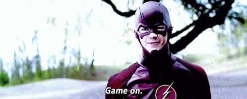 Gif of the camera zooming in on Barry Allen in his Flash suit, grinning slightly as he says, 