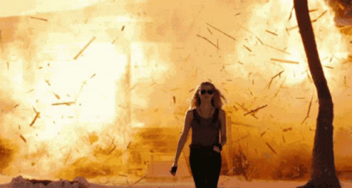 Gif - woman resolutely walks away from an explding house