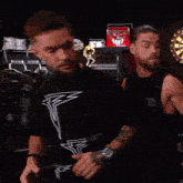 two men are standing in front of a dart board with the words that wasn 't us on the bottom