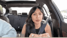 a woman sitting in the back seat of a car